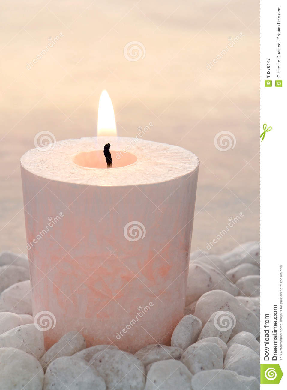 Memorial Candle Softly Glowing And Burning On A Bed Of White Pebbles