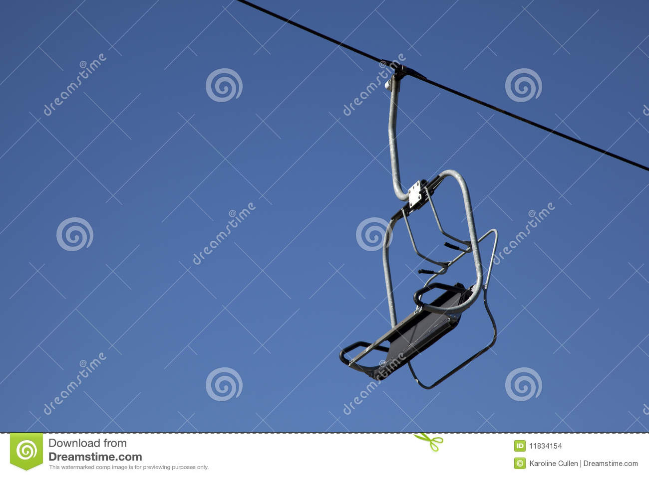 An Empty Chair On A Ski Lift Against A Clear Blue Sky 