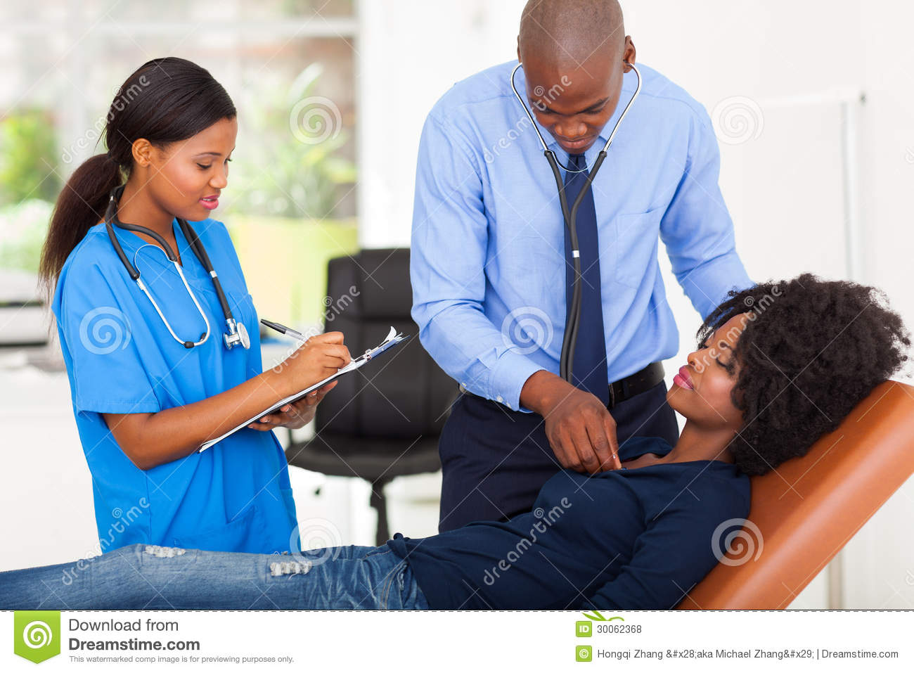 African American Doctor And Nurse Examining Female Patient On    