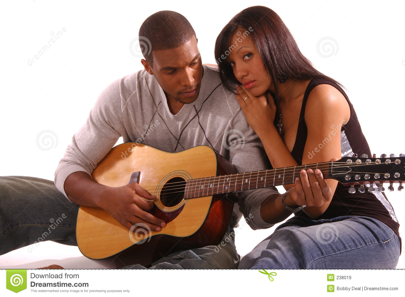 African American Couple Snuggled Up Together While The Man Plays    