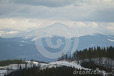 High Snowy Mountain In Foggy Weather And Clouds