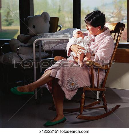 Mother Holding Newborn Baby Sitting In Rocking Chair View Large Photo