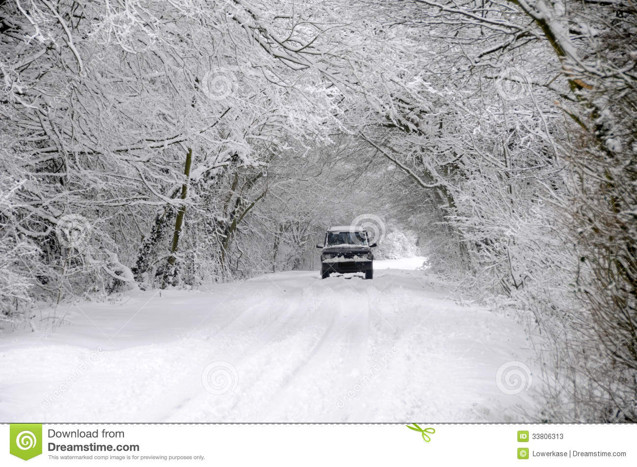 Car Driving On Winter Snow Covered Country Lane Through Woodland Trees    