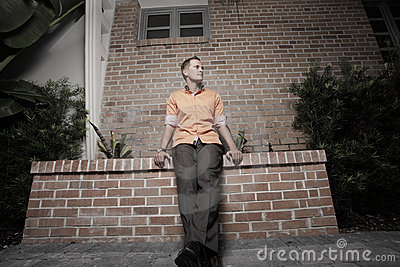 Stylish Man Sitting On A Building Ledge Royalty Free Stock Images