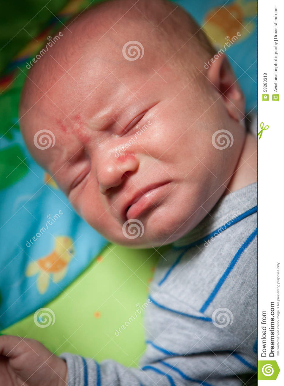 Baby Crying With Angry Expression Frowning Lying On Colorful Blanket