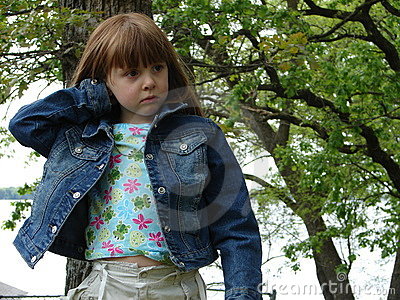 Little Girl Standing Outside In Jean Jacket Frowning