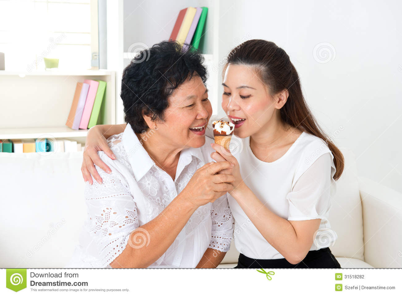 Beautiful Senior Mother And Adult Daughter Eating Dessert Together