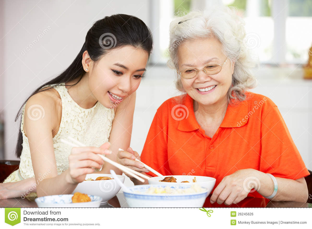 Chinese Mother And Adult Daughter Eating Meal Royalty Free Stock Image