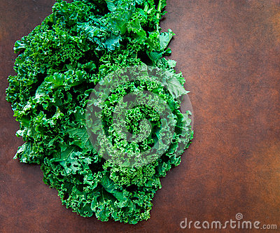 Bunch Of Fresh Raw Green Kale Plant On Brown Table 