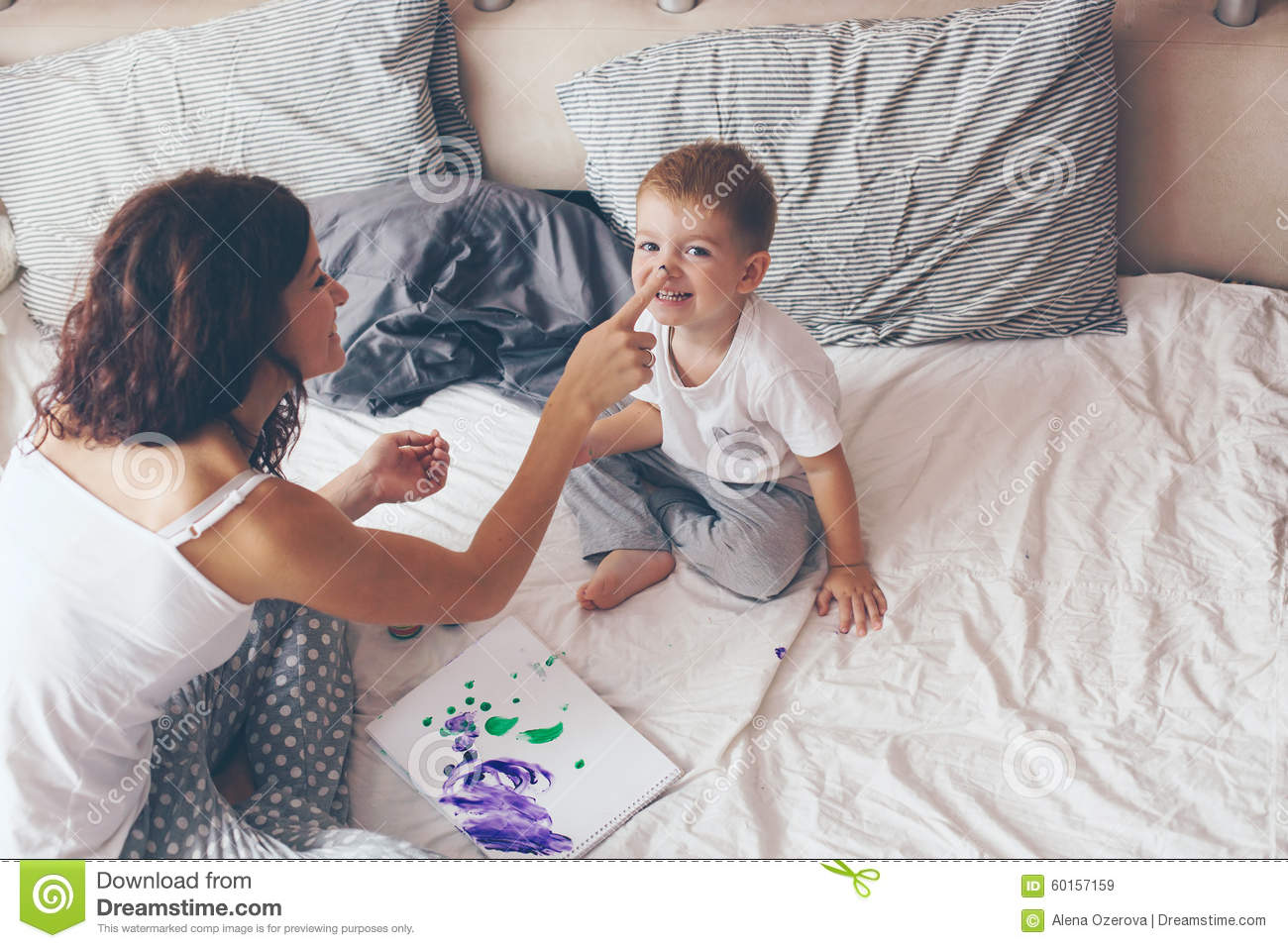     Little Son Dressed In Pajamas Are Relaxing And Playing In The Bed At
