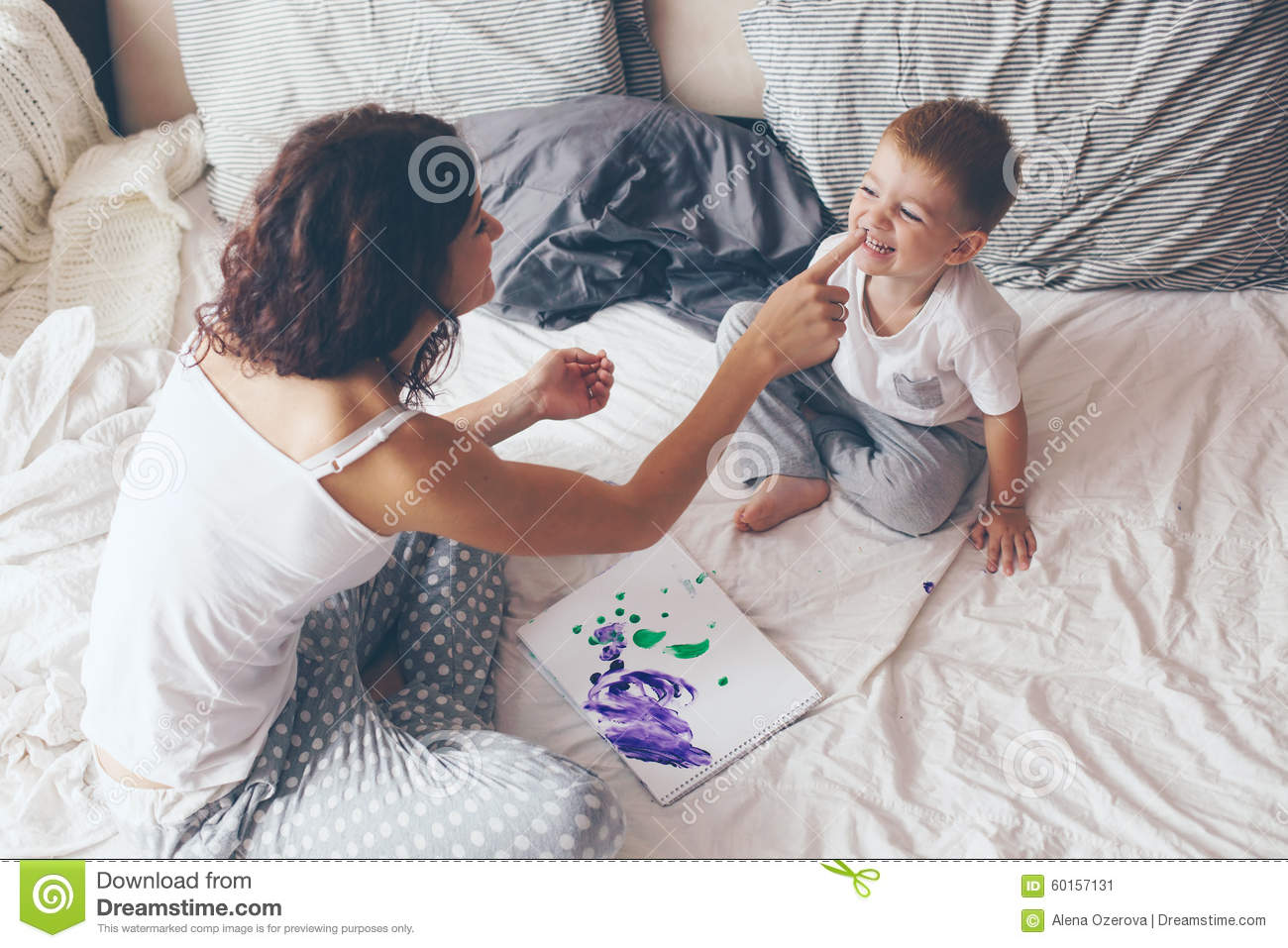 Little Son Dressed In Pajamas Are Relaxing And Playing In The Bed At