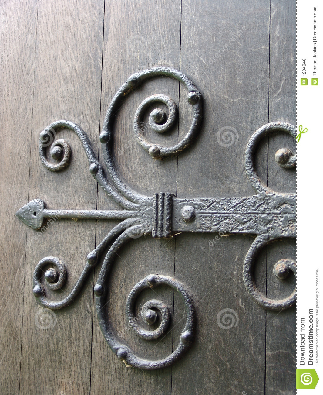 Ancient Wrought Iron Ornate Door Hinge On Old Wooden Door