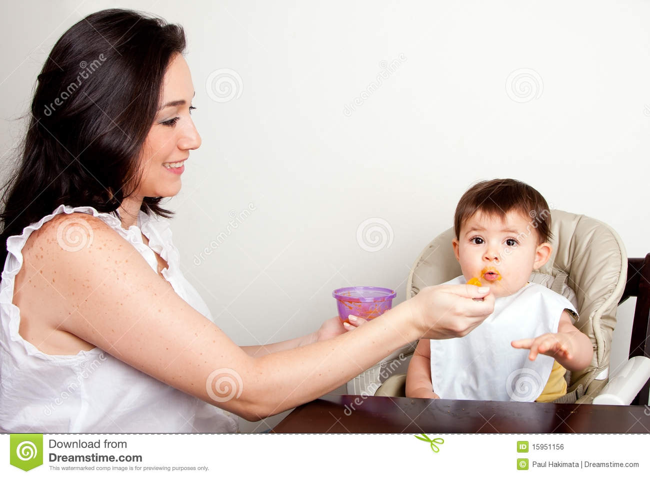 Orange Puree With Spoon Infant Eats Messy While Sitting At Table
