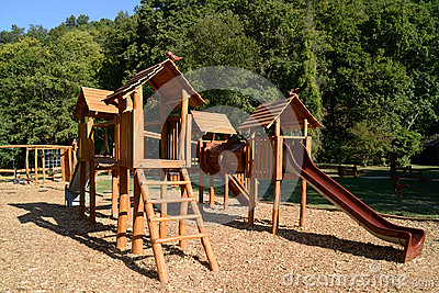 Wooden Playground Equipment With Slides At Summer Time
