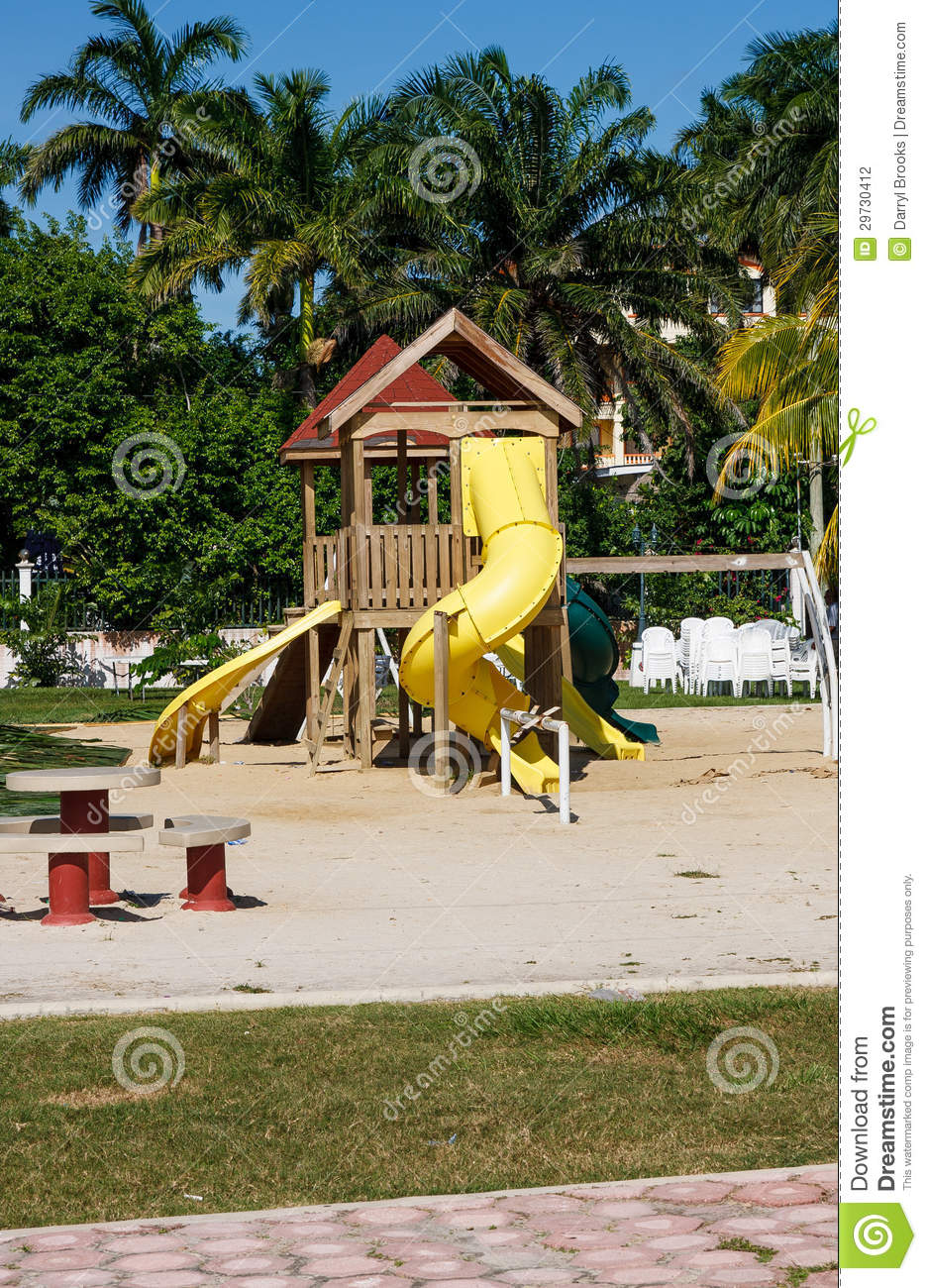 Yellow Plastic Sliding Boards On Wood Playground In A Tropical Park