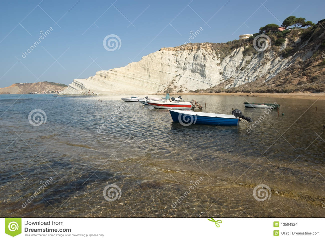 White Cliffs And Boats Moored In The Clear Water Of A Sicilian Bay
