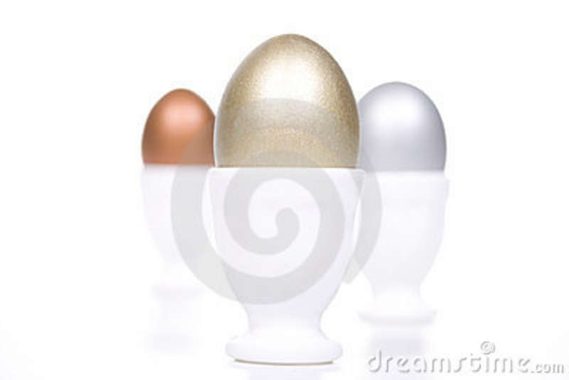 Gold Silver And Bronze Eggs In A White Eggcup  Concept For First