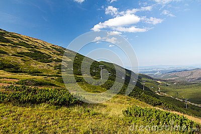 View On Mountains In Summer With Ski Lift On Blue Sky Background Stock