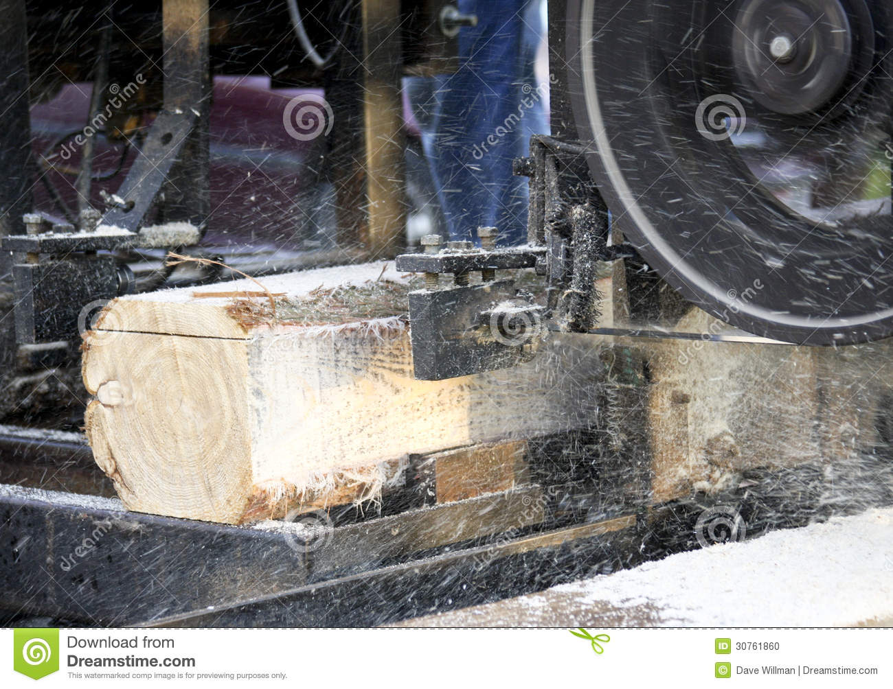 Sawdust And Chips Fly As A Sawmill Cuts Logs Into Boards