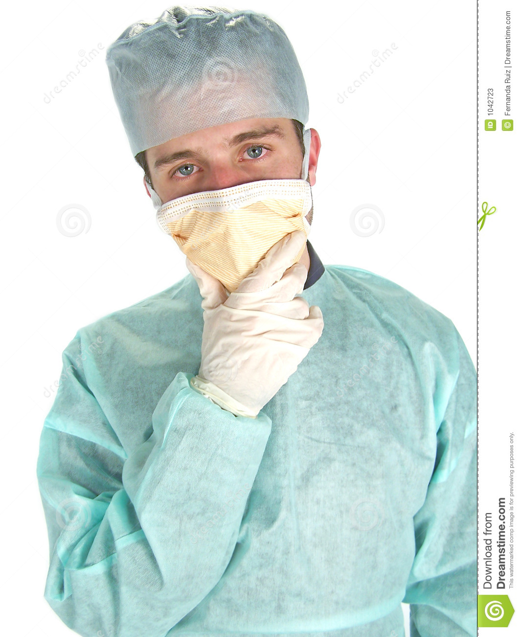 Male Surgeon Wearing Mask With Hand Under Chin Looking At Camera