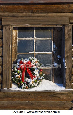 Decorated Christmas Wreath Sits In The Windowsill Of A Rustic Log Barn