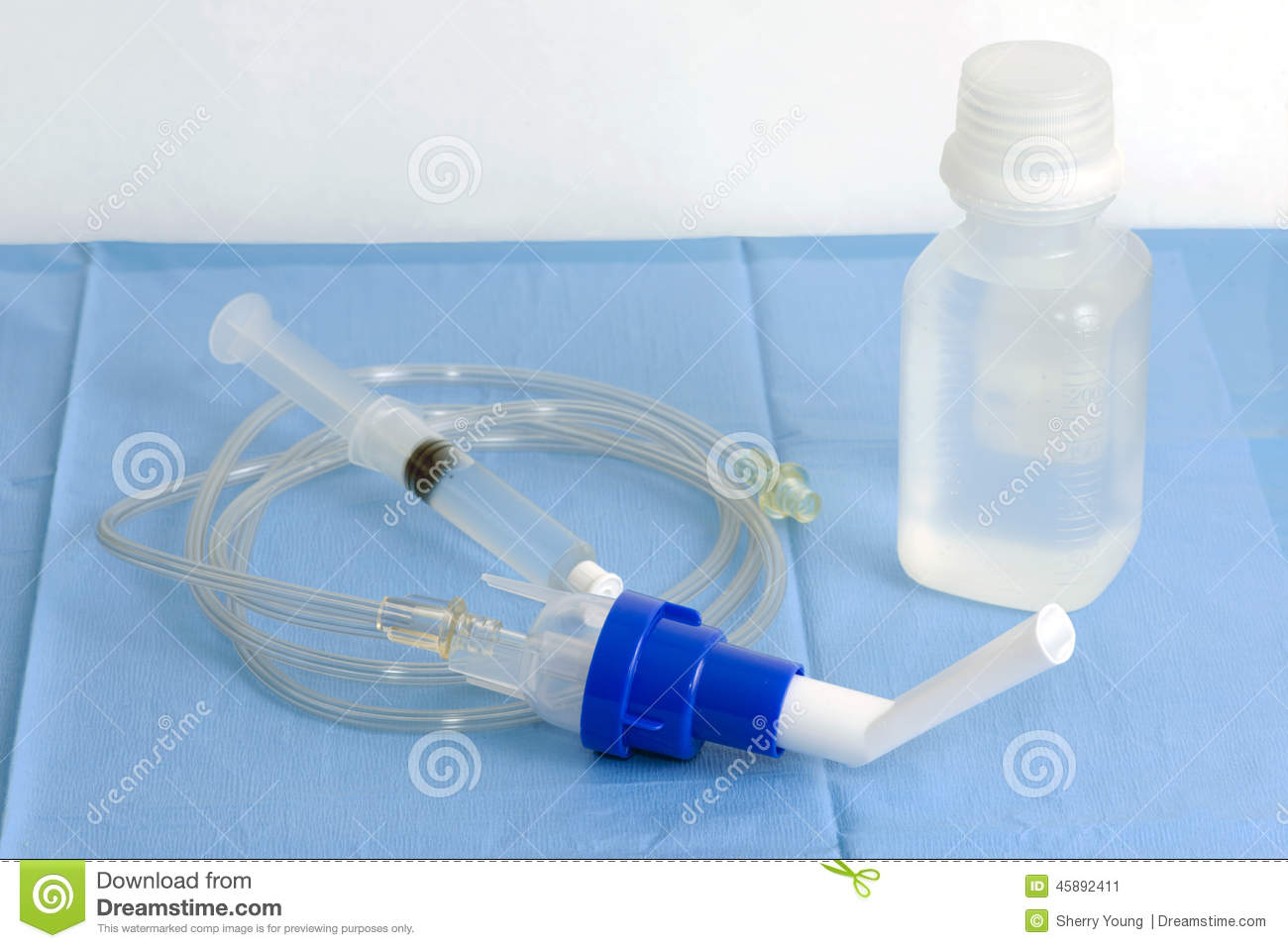 Inhalation Therapy Chamber And Sterile Saline On Blue Sterile Drape 