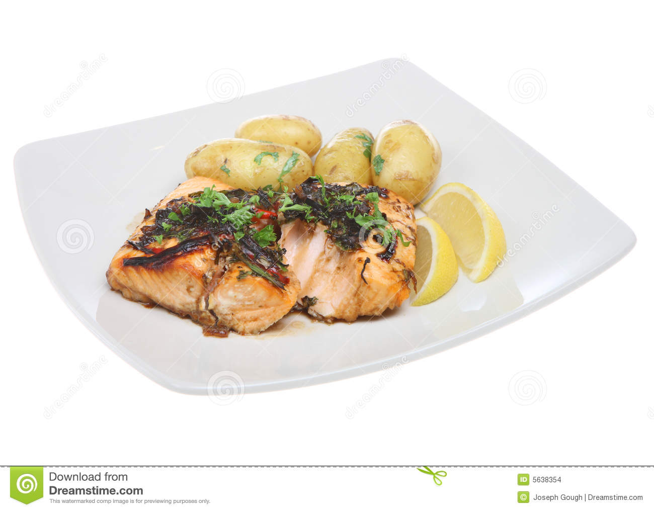 Baked Salmon With Herbs New Potatoes And Lemon Wedges 