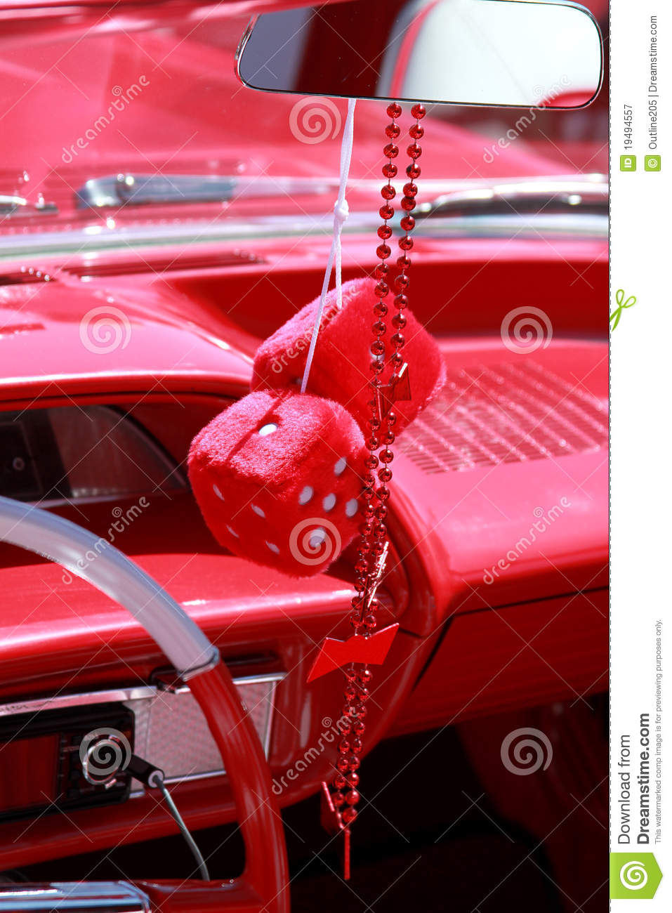 Fuzzy Dice Hanging From The Rearview Mirror Of A Classic Red Car