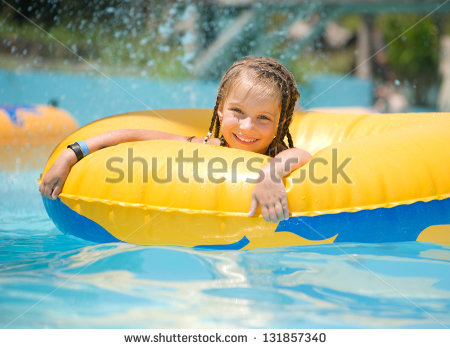 Cute Little Girl Sitting On Inflatable Ring In Swimming Pool    Stock