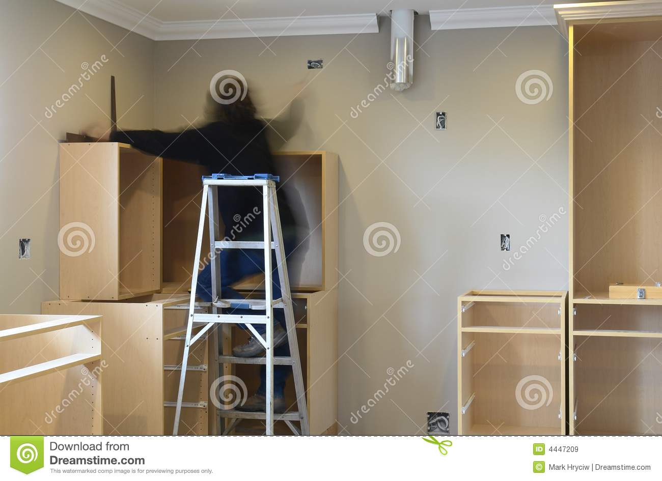 Cabinetmaker Working At Installing New Kitchen Cabinets In A Home