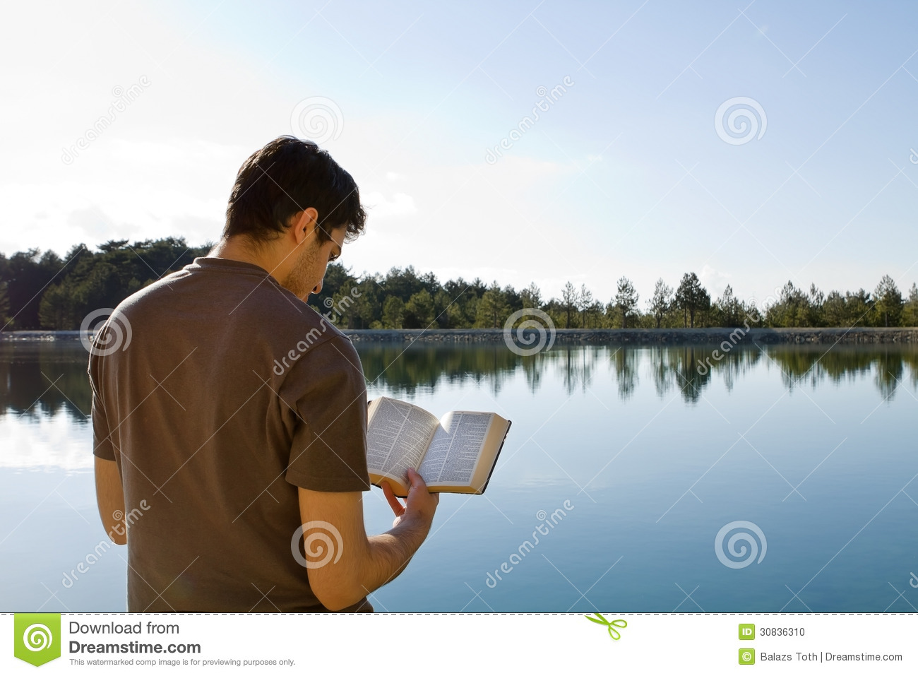 Young Man In Front Of Lake Reading The Bible  King James Version