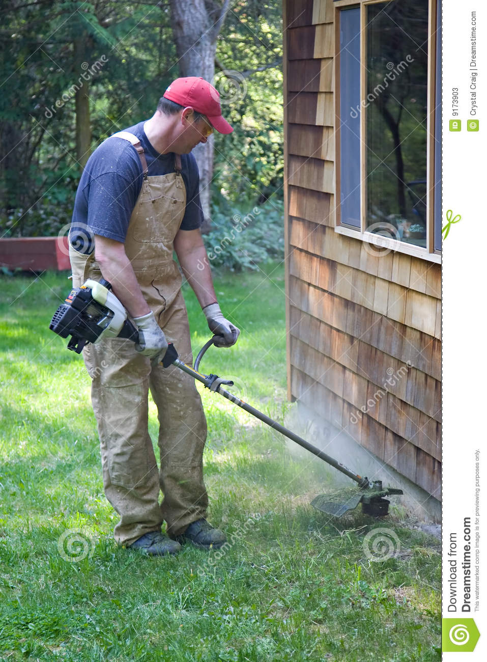 Man Using A Gas Powered Weed Eater To Trim The Lawn Edges Of A Yard