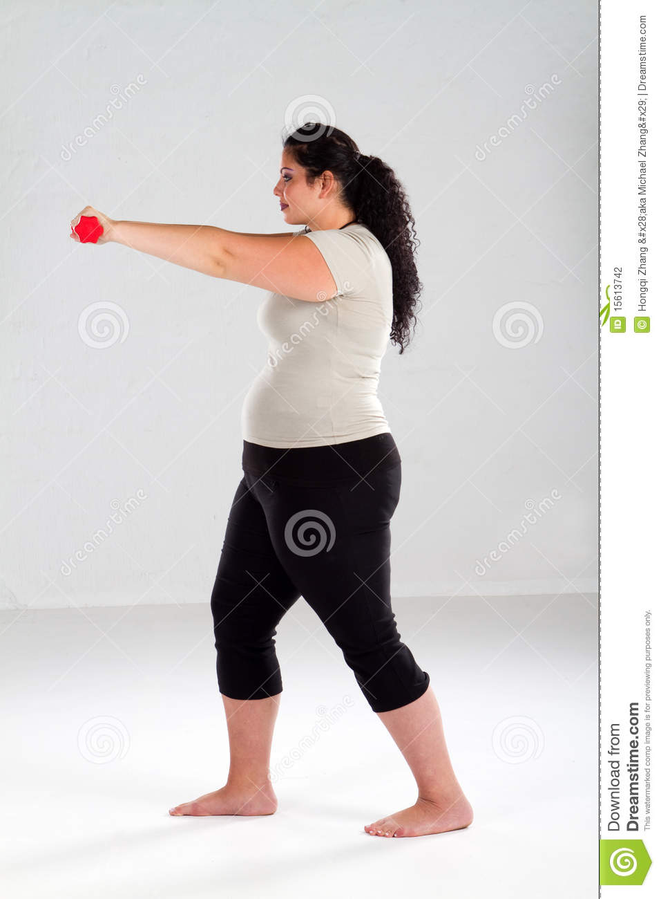 Portrait Of An Overweight Woman Working Out With Hand Weights On White    