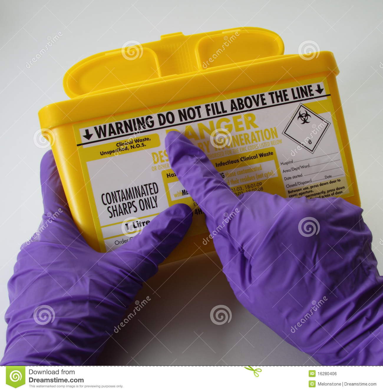 Hands In Purple Medical Gloves Holding A Sharps Hypodermic Needle    