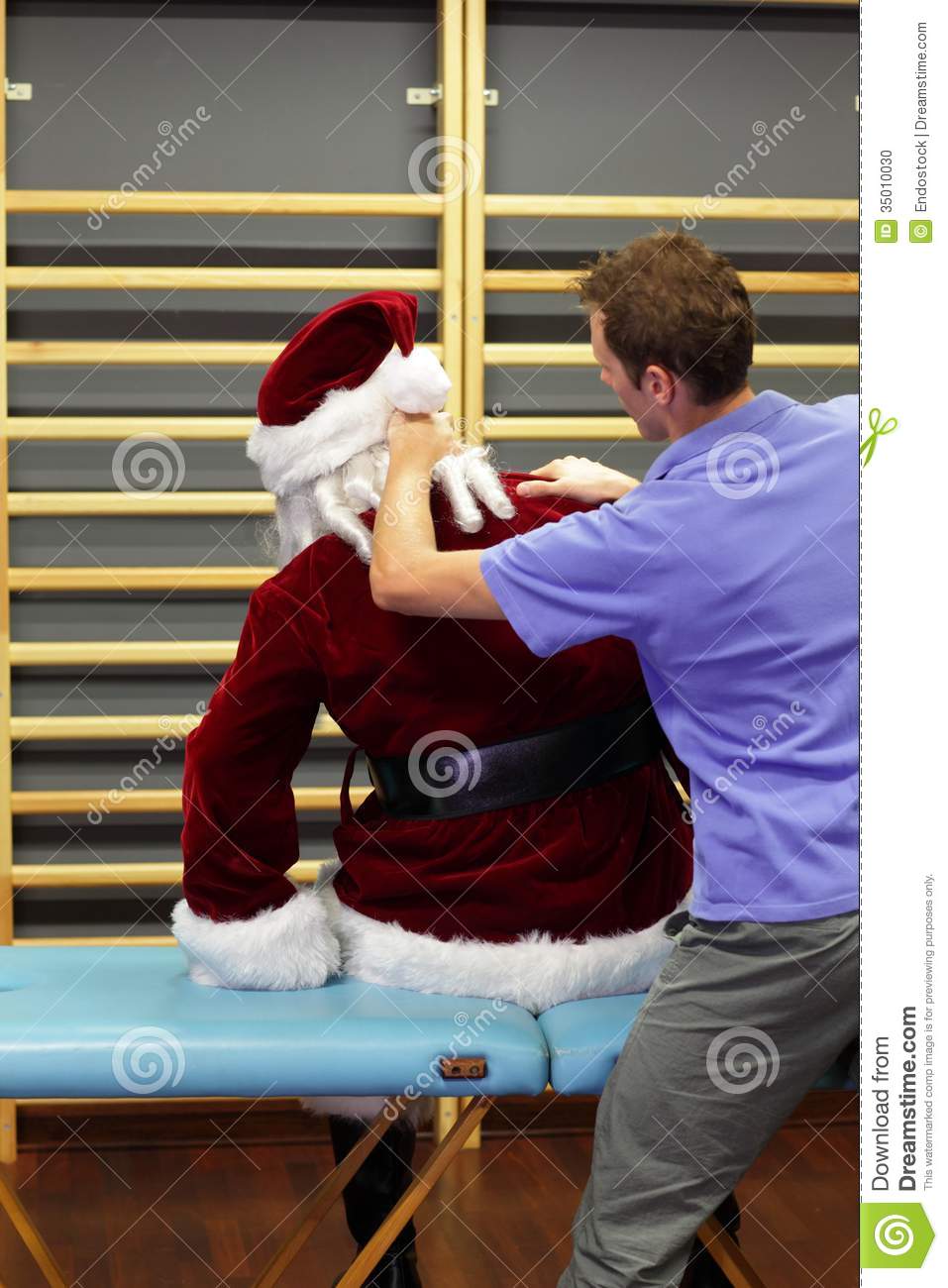 Male Therapist Massaging Overworked Santa Claus Stock Photo   Image
