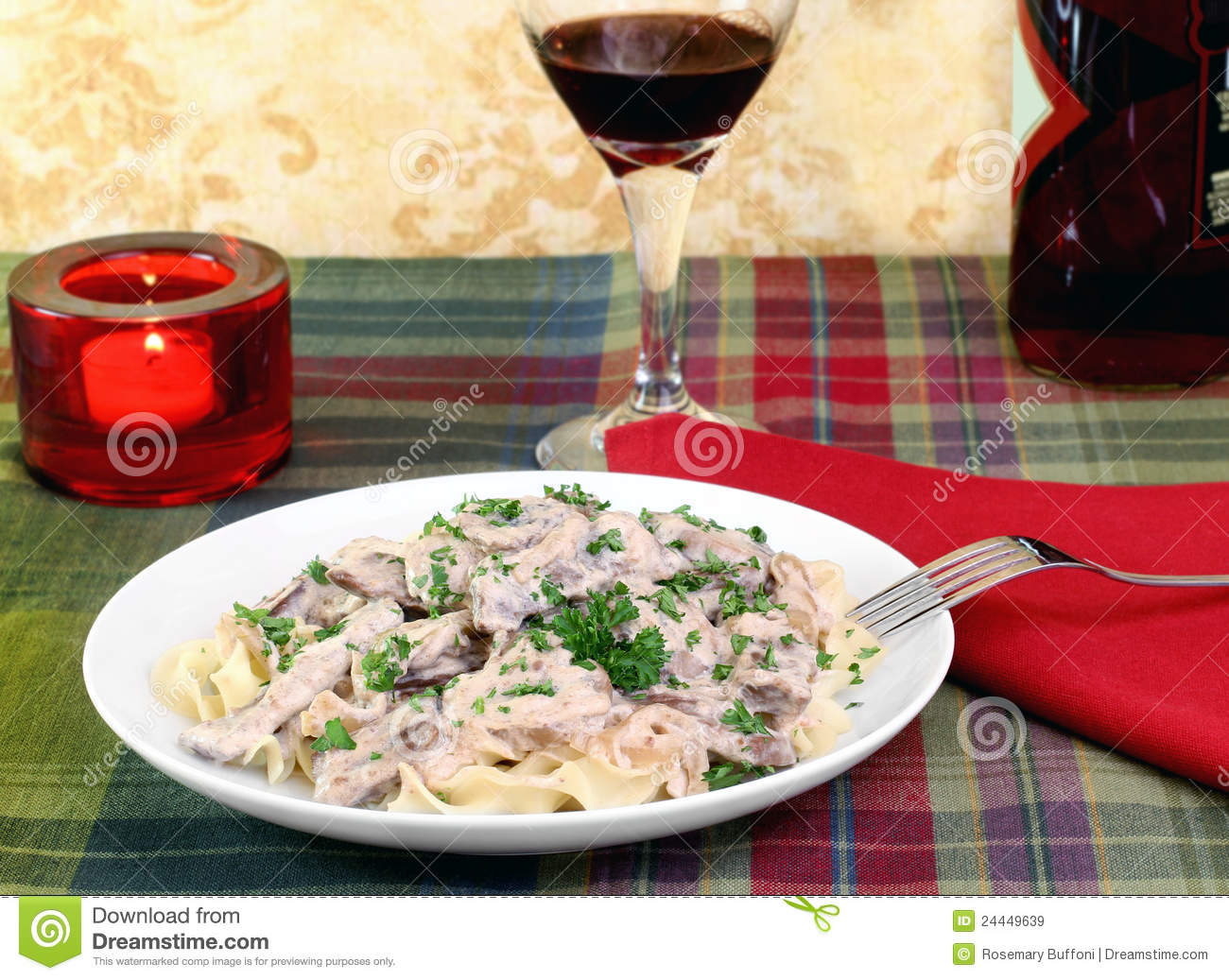 Beef Stroganoff And Egg Noodles With Wine And A Lit Candle In A Dinner    