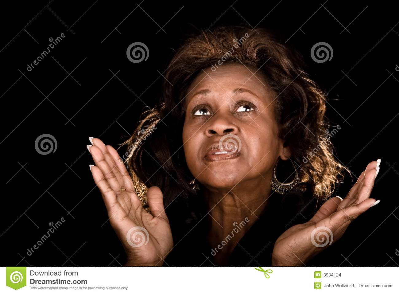 African American Woman Praying With Hands Raised Over Black