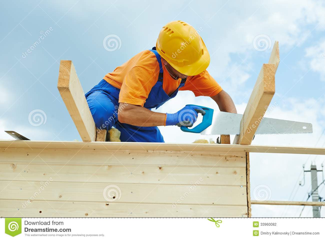     Worker Sawing Wood Board With Hand Saw On Roof Installation Work