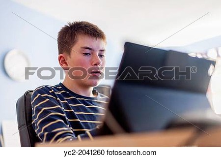 Stock Photography Of A 13 Year Old Boy Looking At His Computer Tablet