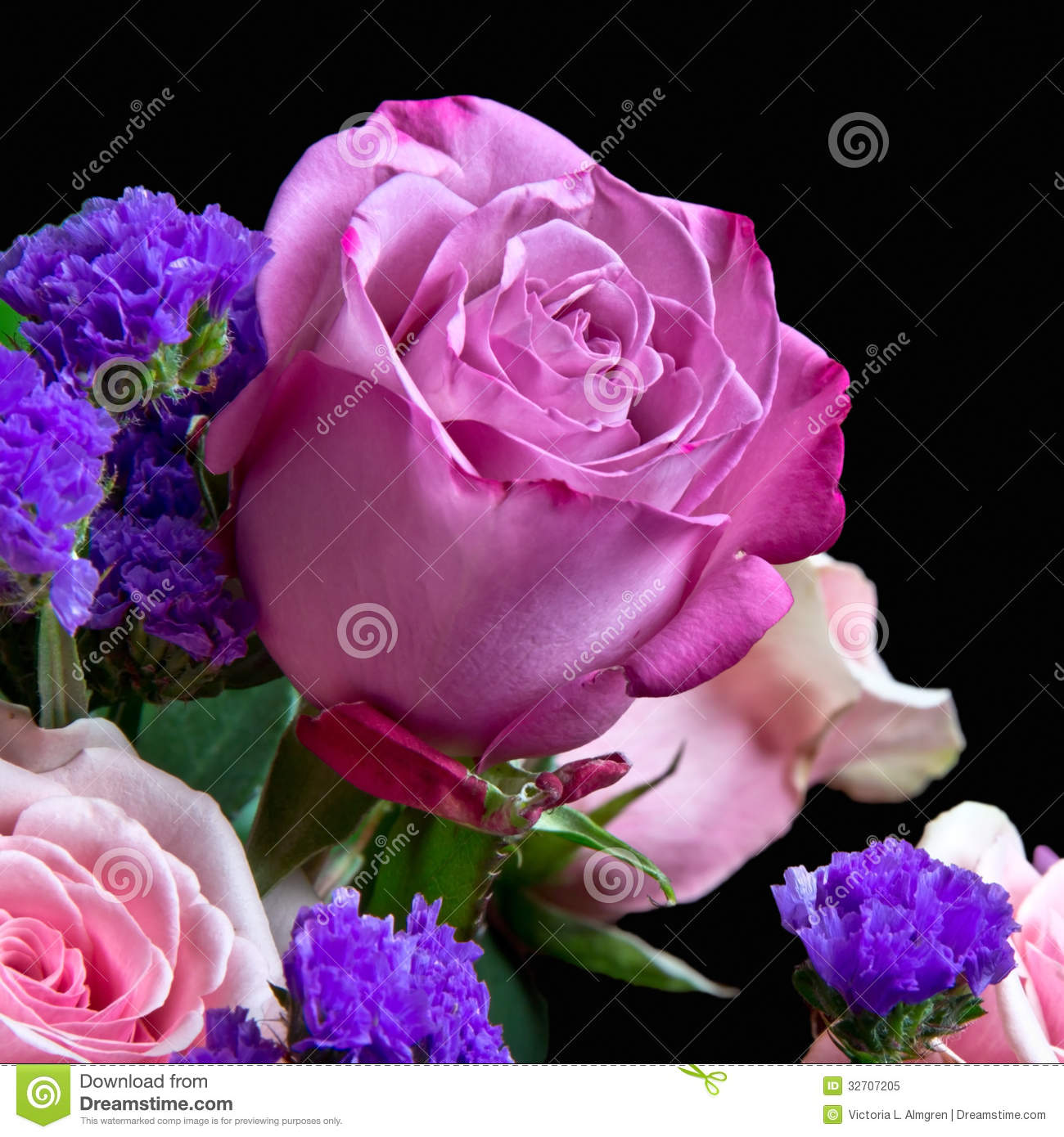View Of A Bouquet Of Roses And Purple Statice With Focus On One Pink    