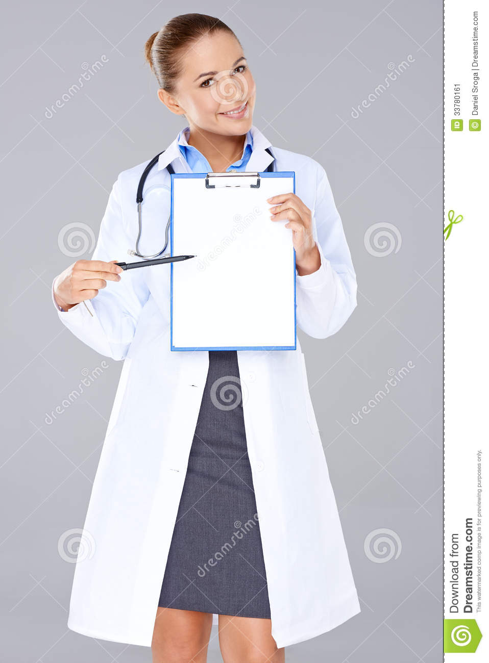 Attractive Female Doctor In A Lab Coat Displaying A Blank Clipboard In