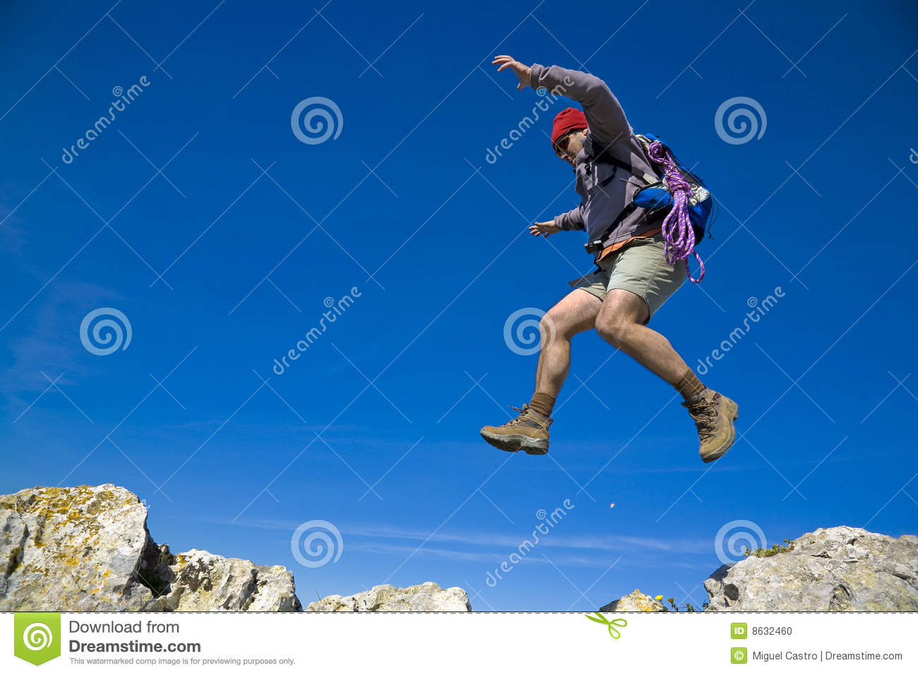 Leap Of Faith   A Mountaineer Jumping Trough The Rocks Over A Clear