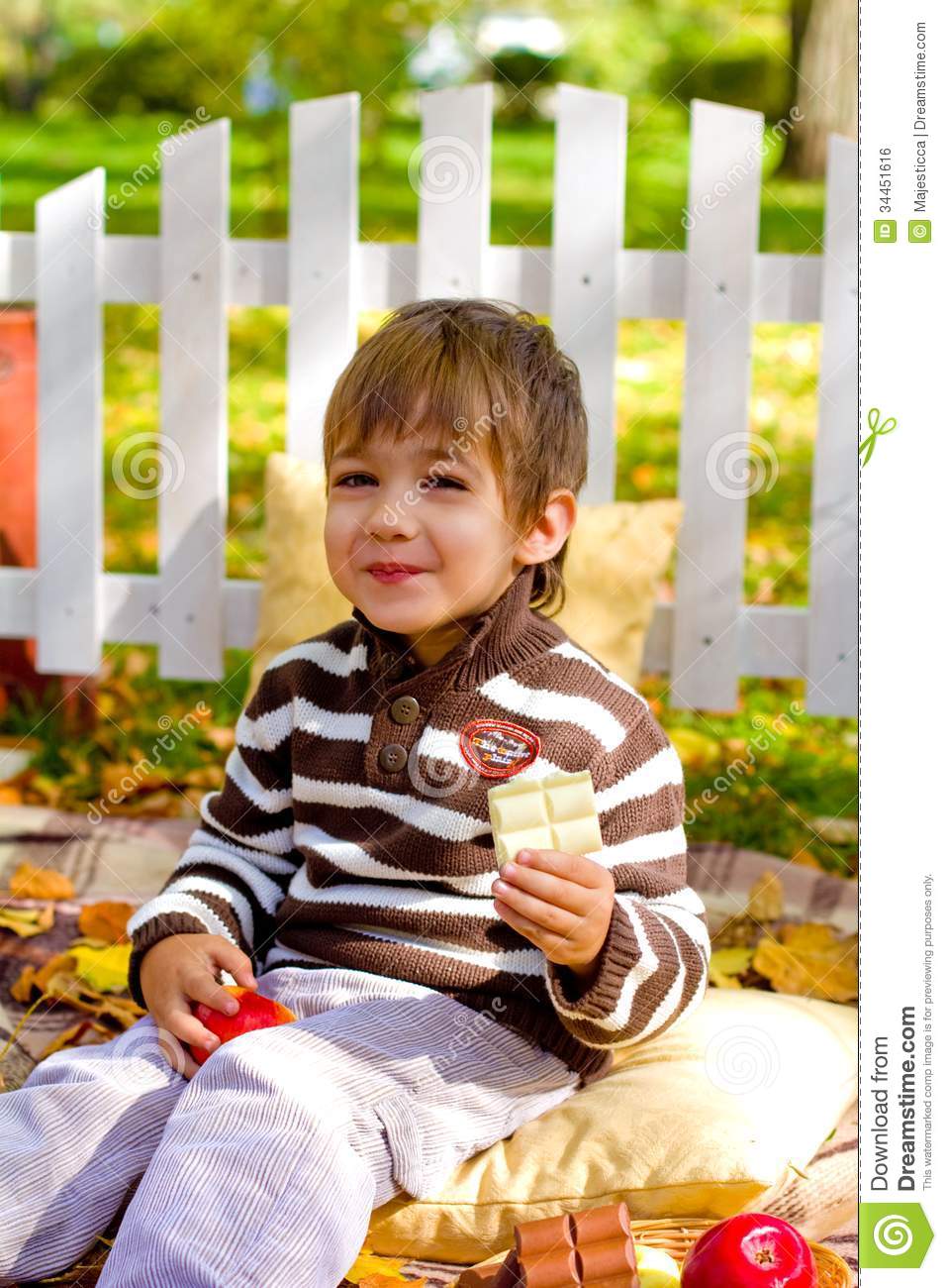Happy Little Boy Eating Chocolate In The Autumn Forest Royalty Free