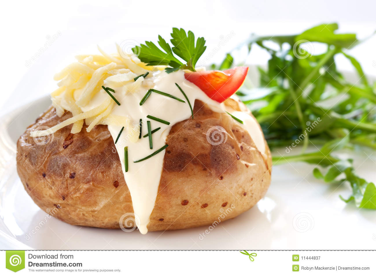 Baked Potato Filled With Sour Cream And Grated Cheese With Arugula On