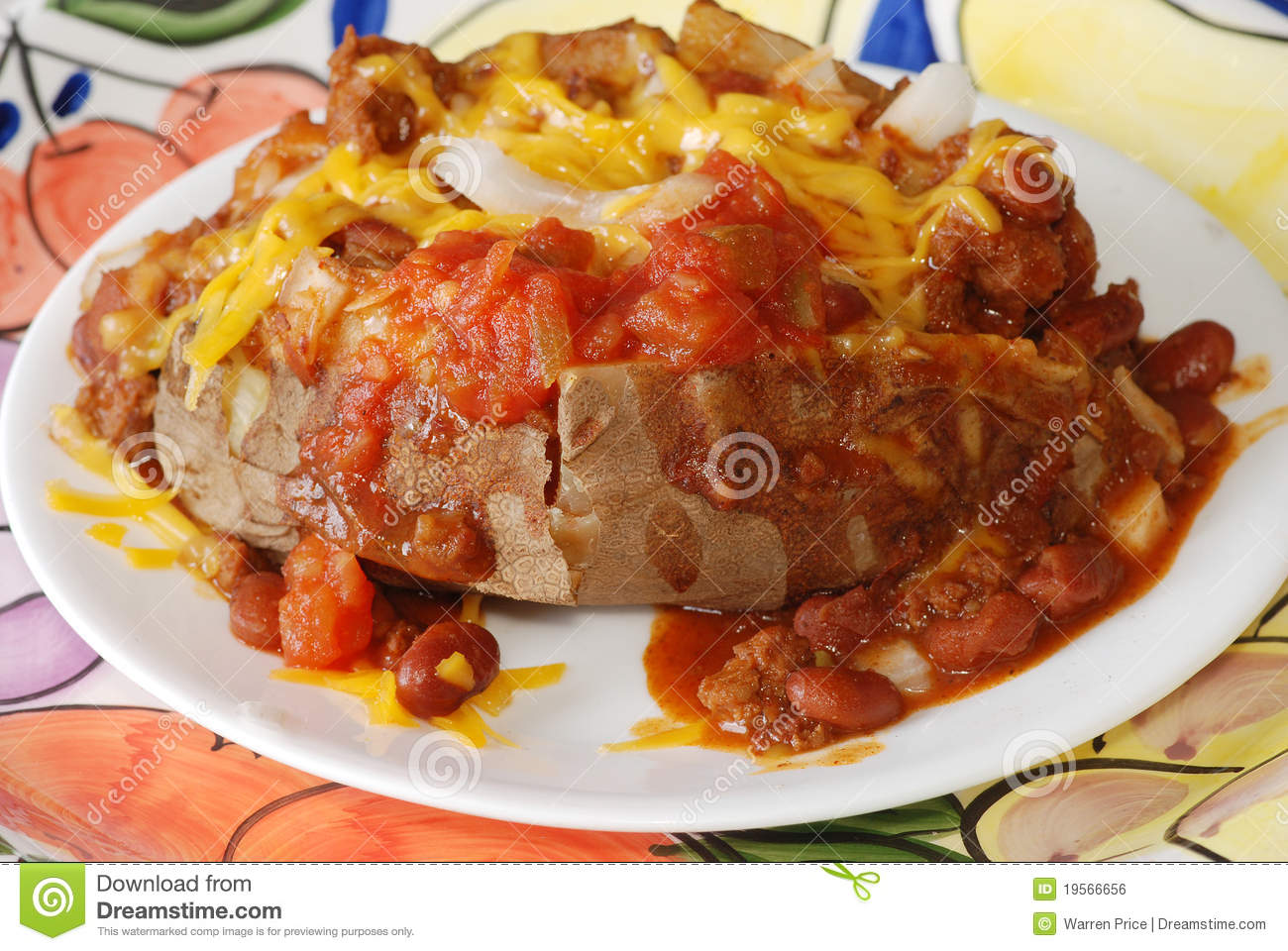 Baked Potato Smothered In Chili Cheese Onions And Salsa And Served    