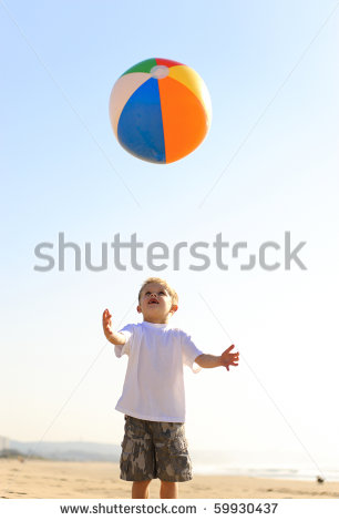 Happy Kid Throws His Beach Ball In The Air And Tries To Catch It