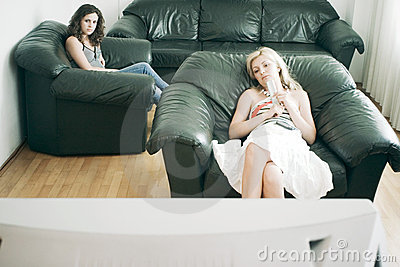 Two Women Sitting In The Living Room Watching Tv