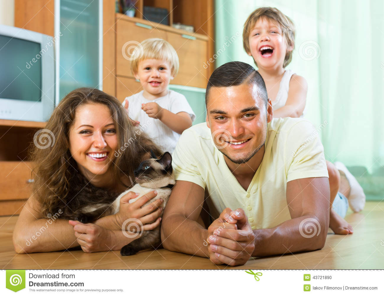 Family Portrait Of Happy Parents And Two Daughters With Siamese  Focus    