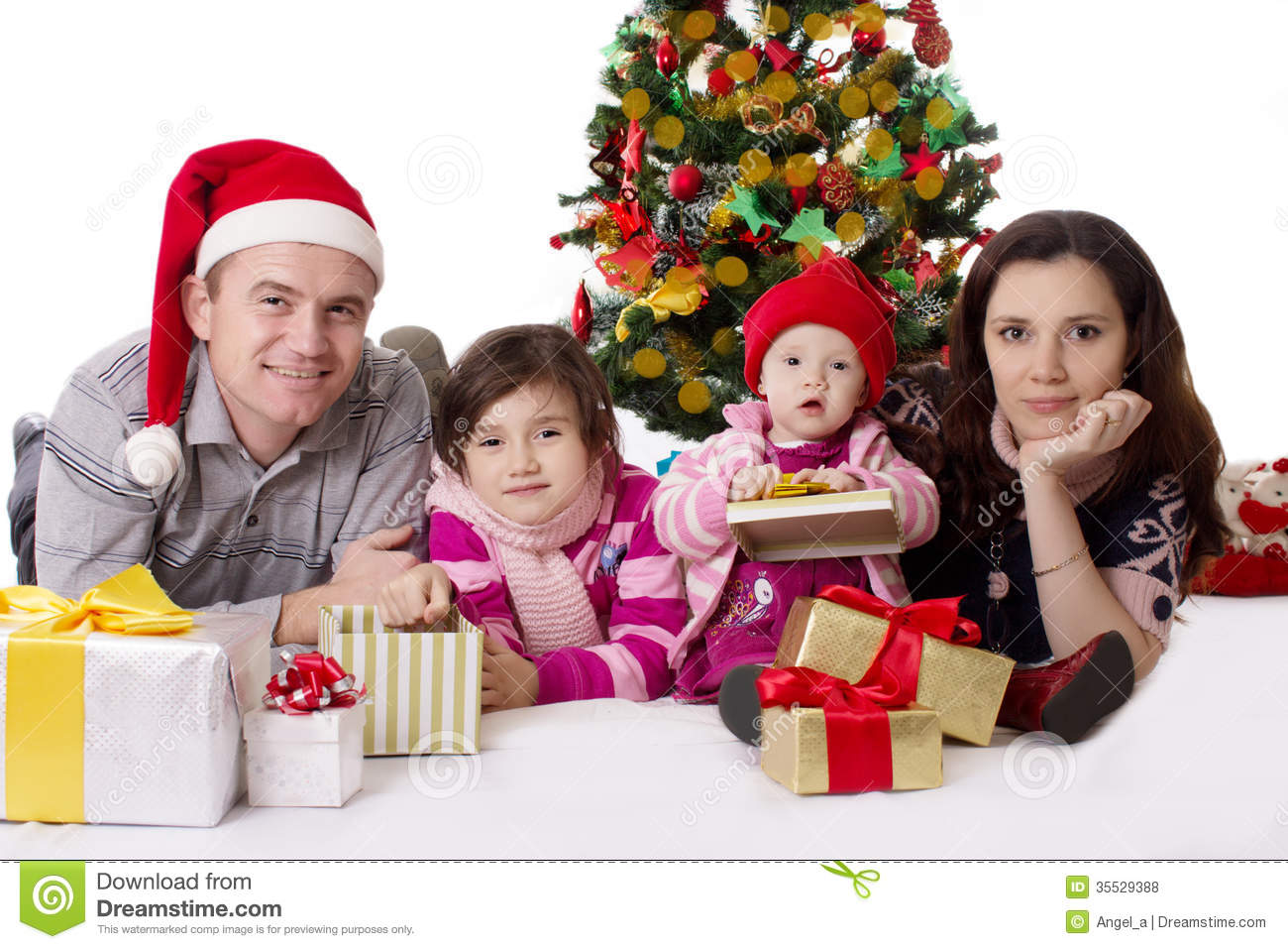 Happy Family With Two Little Daughters Lying Under Christmas Tree Over    