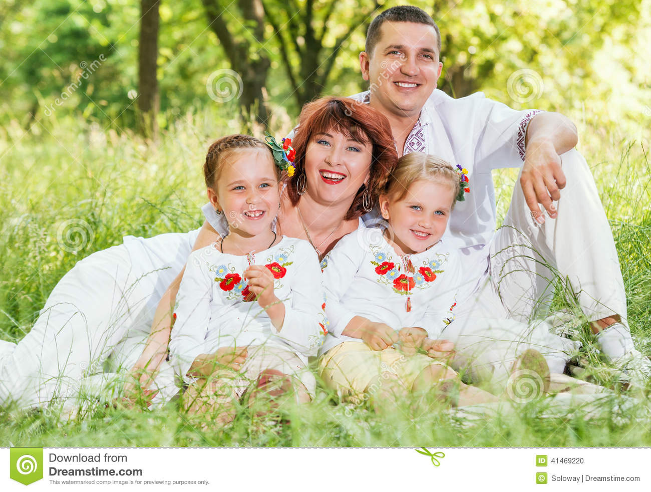 Stock Photo  Happy Family With Two Daughters Sitting On Green Meadow